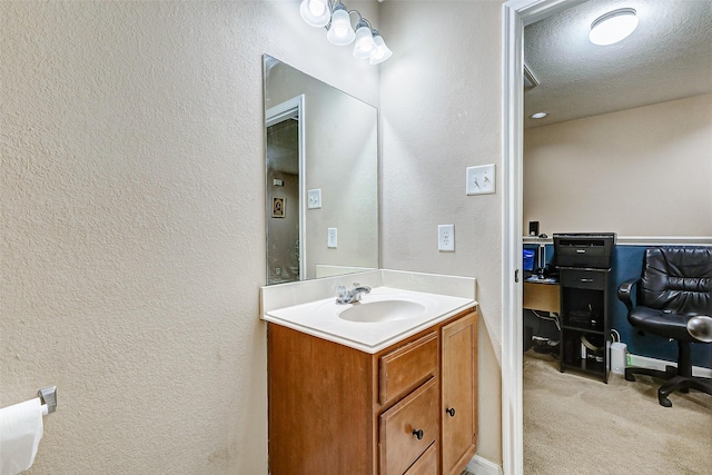 bathroom with vanity, a textured ceiling, and a textured wall
