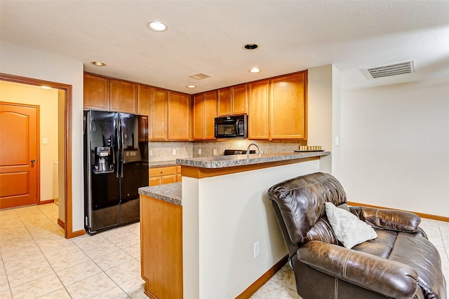 kitchen with a peninsula, baseboards, decorative backsplash, visible vents, and black appliances