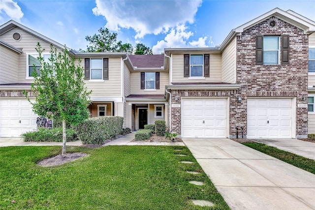 view of property with brick siding, an attached garage, driveway, and a front yard