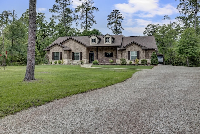 view of front of house featuring brick siding, a shingled roof, and a front lawn