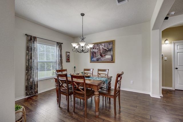 dining space featuring an inviting chandelier, arched walkways, baseboards, visible vents, and dark wood-style floors