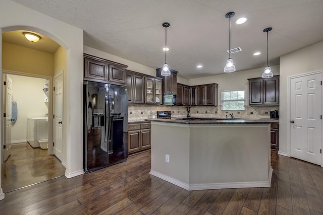 kitchen featuring visible vents, dark wood-style flooring, dark brown cabinetry, arched walkways, and black appliances