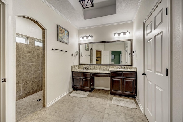 bathroom with double vanity, walk in shower, ornamental molding, and a sink