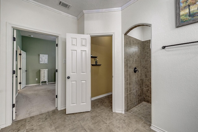 full bathroom with tile patterned floors, baseboards, visible vents, ornamental molding, and tiled shower
