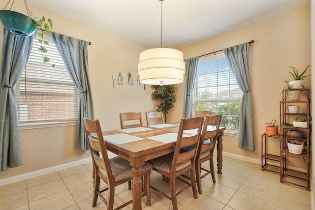 dining space featuring baseboards and light tile patterned flooring