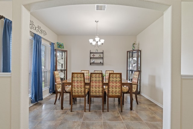 tiled dining space with baseboards, a chandelier, and visible vents