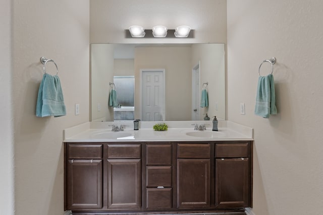 bathroom featuring a sink and double vanity