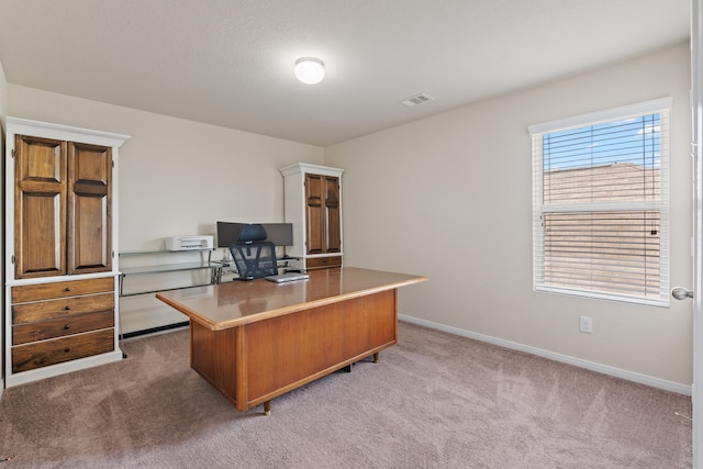 office area with baseboards, light colored carpet, and visible vents