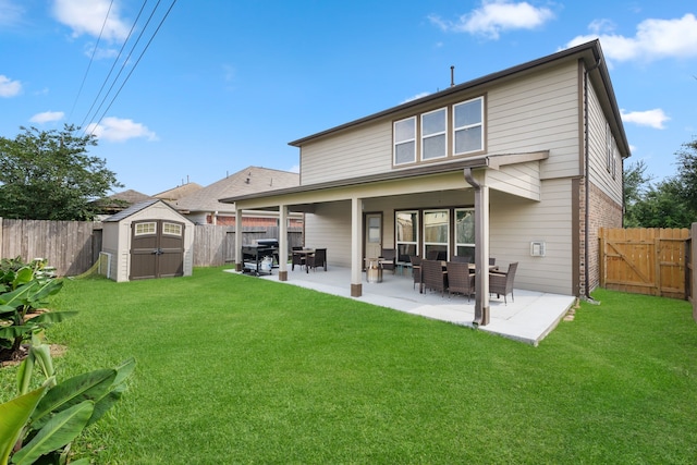 back of house with an outdoor structure, a patio, a fenced backyard, a storage shed, and a yard