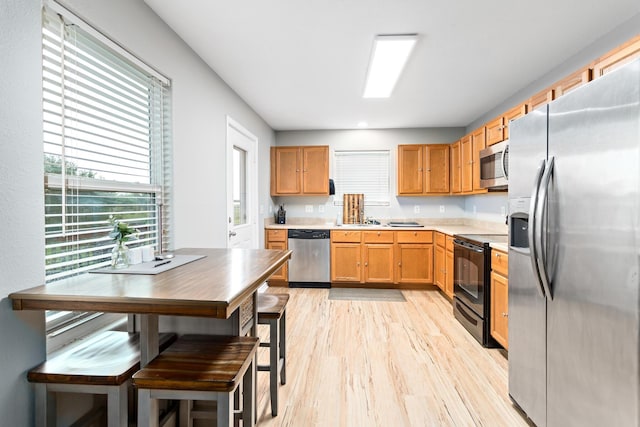 kitchen with light countertops, light wood finished floors, and stainless steel appliances