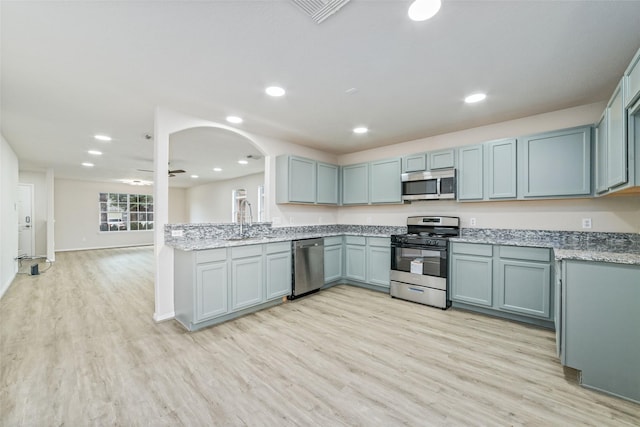 kitchen with a sink, recessed lighting, stainless steel appliances, and light wood finished floors