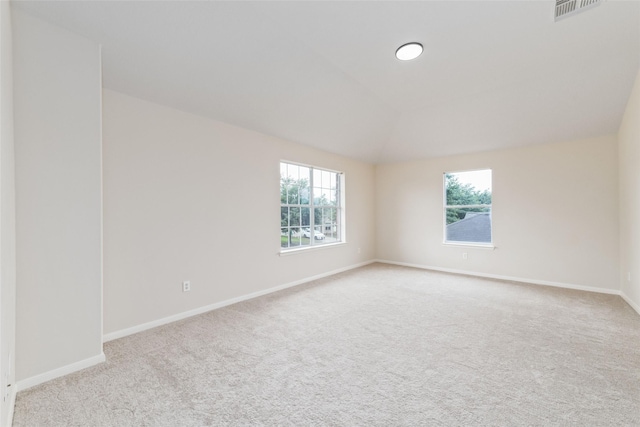 spare room with baseboards, a wealth of natural light, carpet flooring, and visible vents