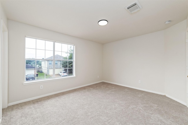 carpeted empty room featuring baseboards and visible vents