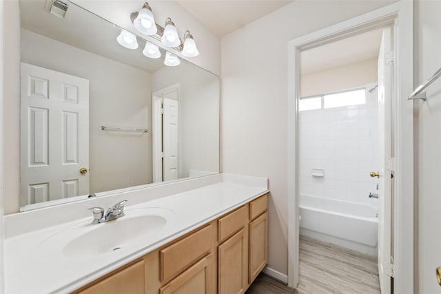 bathroom with shower / bath combination, visible vents, wood finished floors, and vanity
