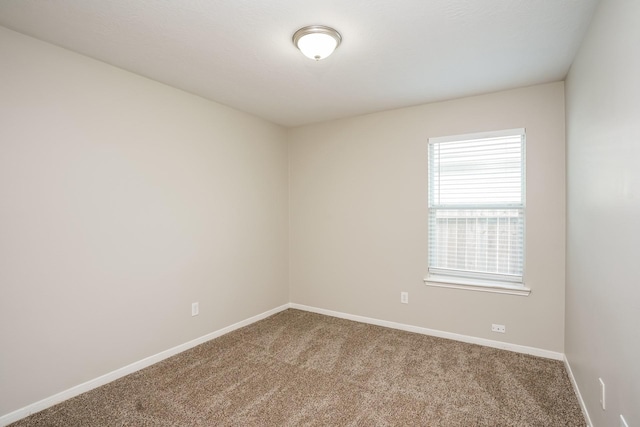 empty room featuring carpet floors and baseboards