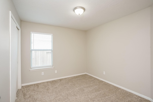 carpeted empty room with baseboards