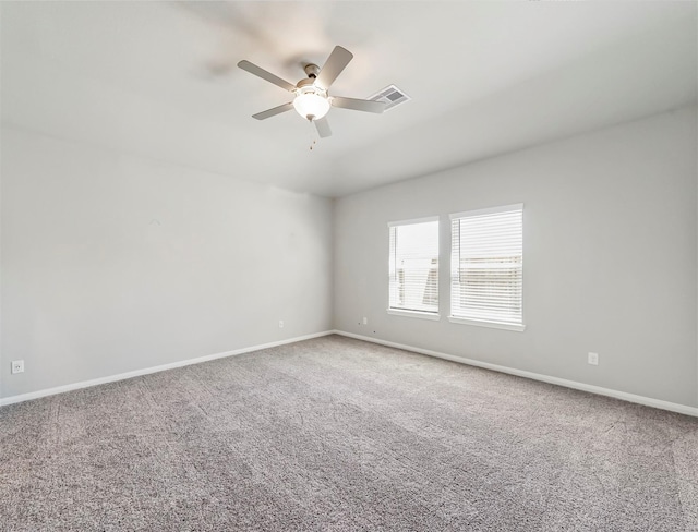 spare room featuring visible vents, a ceiling fan, carpet, and baseboards