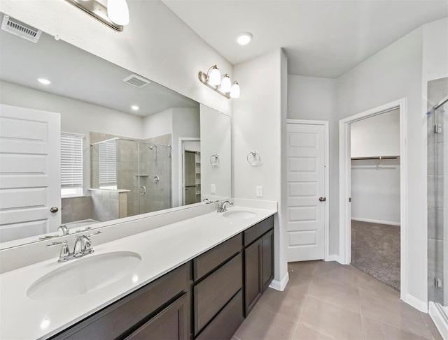 full bathroom featuring visible vents, a stall shower, a sink, tile patterned floors, and a spacious closet