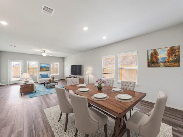 dining room with a ceiling fan, baseboards, visible vents, and wood finished floors