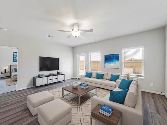 living area with visible vents, baseboards, ceiling fan, and wood finished floors