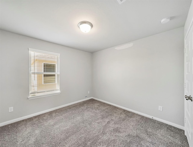 carpeted empty room with baseboards
