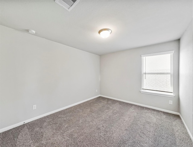 carpeted spare room with baseboards and visible vents