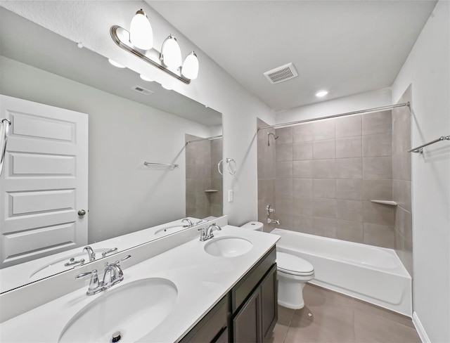 bathroom with toilet, tile patterned floors, visible vents, and a sink