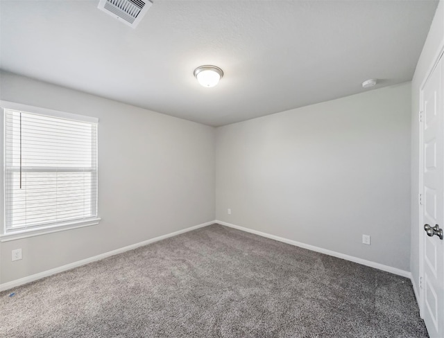 empty room with carpet flooring, baseboards, and visible vents