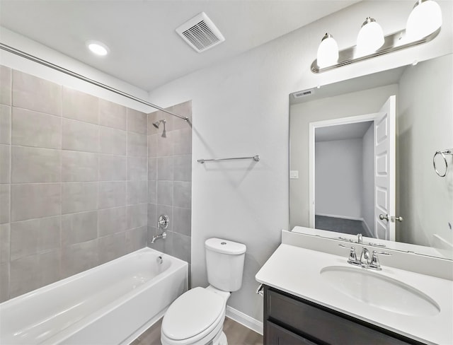 bathroom featuring visible vents, bathtub / shower combination, vanity, baseboards, and toilet