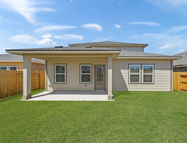rear view of house featuring a yard, a fenced backyard, and a patio area