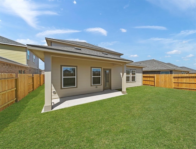 rear view of property featuring a lawn, a fenced backyard, and a patio area
