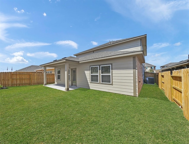 rear view of property featuring a yard, a patio, central AC, and a fenced backyard