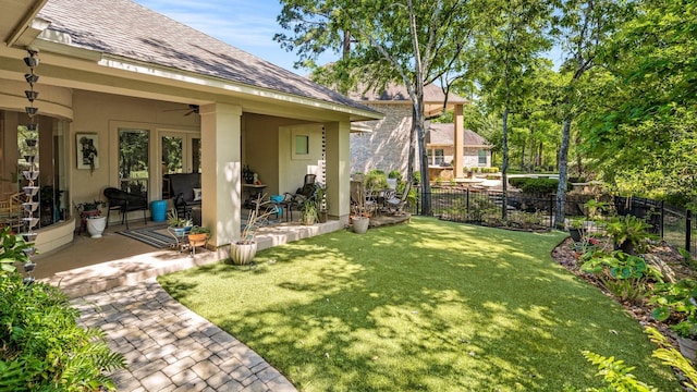view of yard featuring a patio, ceiling fan, and fence