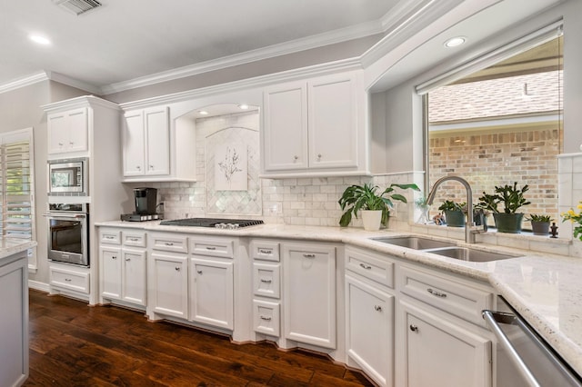 kitchen with decorative backsplash, crown molding, a sink, white cabinets, and stainless steel appliances