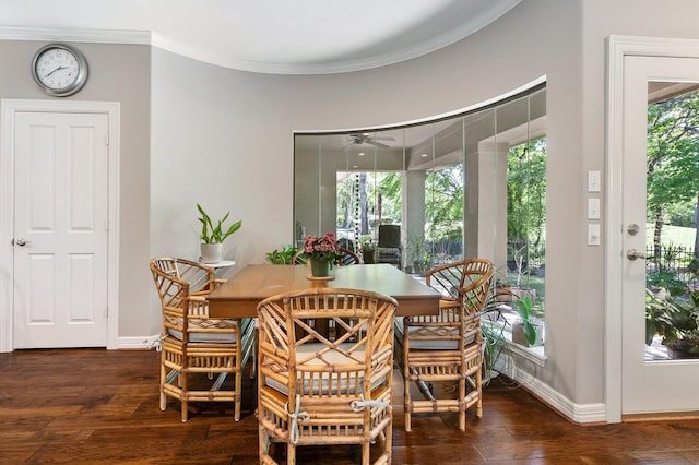dining space with crown molding, baseboards, and wood finished floors
