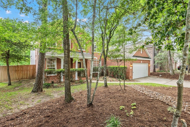 view of front of property with fence, concrete driveway, a garage, and brick siding