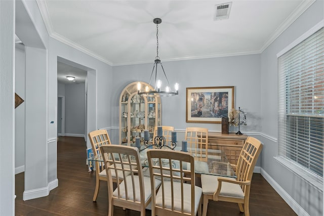 dining space featuring baseboards, visible vents, hardwood / wood-style flooring, and a chandelier