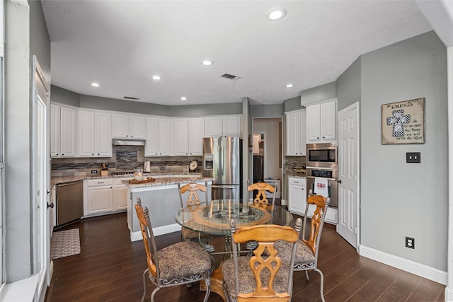 dining room featuring baseboards, dark wood-type flooring, recessed lighting, and visible vents