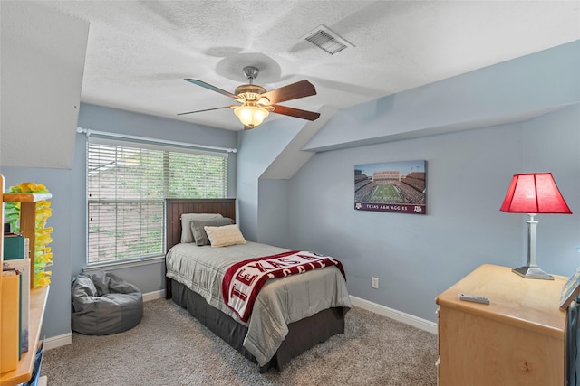bedroom with ceiling fan, a textured ceiling, visible vents, baseboards, and carpet flooring