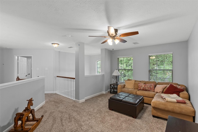 living area with a ceiling fan, a textured ceiling, visible vents, carpet floors, and baseboards