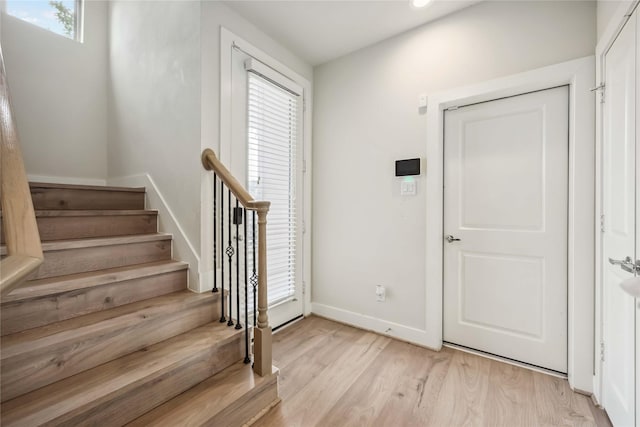 stairway featuring a healthy amount of sunlight, baseboards, recessed lighting, and wood finished floors