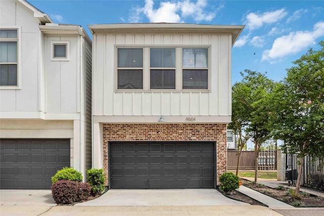 9504 Retriever Way, Houston, TX 77055 - view of front facade with fence, board and batten siding, an attached garage, and brick siding