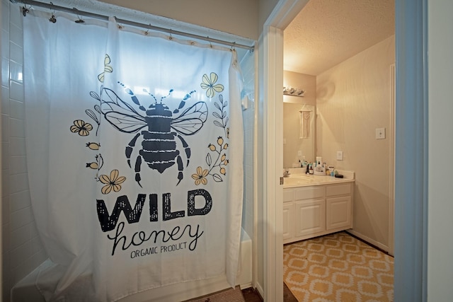 full bathroom with a shower with curtain, a textured ceiling, and vanity