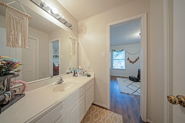 bathroom featuring vanity, baseboards, and wood finished floors