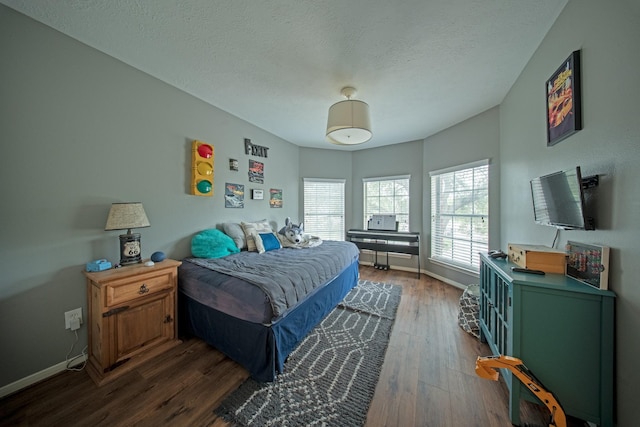 bedroom featuring dark wood-type flooring, a textured ceiling, and baseboards