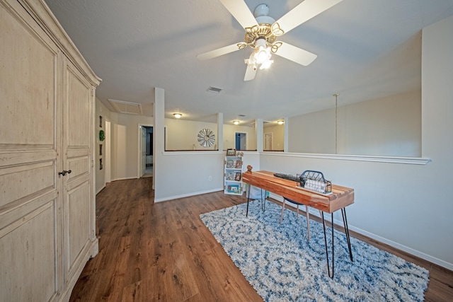 office featuring baseboards, a ceiling fan, attic access, and dark wood-type flooring