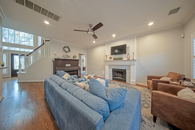 living area with baseboards, visible vents, wood finished floors, and a fireplace