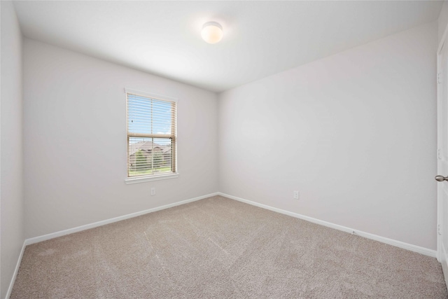 unfurnished room with carpet floors and baseboards