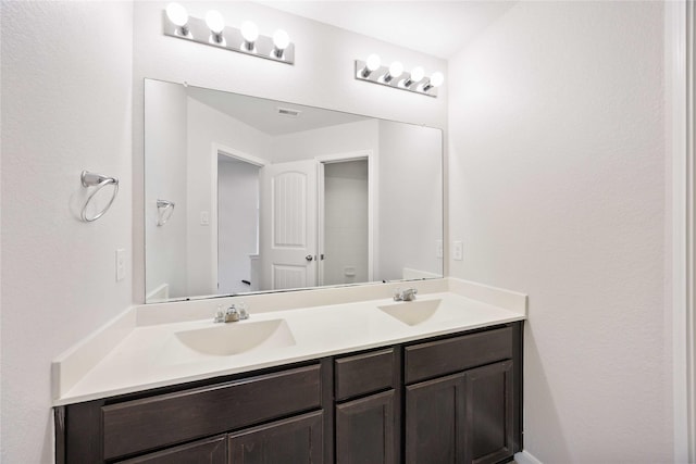 bathroom featuring a sink, double vanity, and visible vents