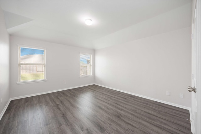 empty room with baseboards and dark wood-style floors